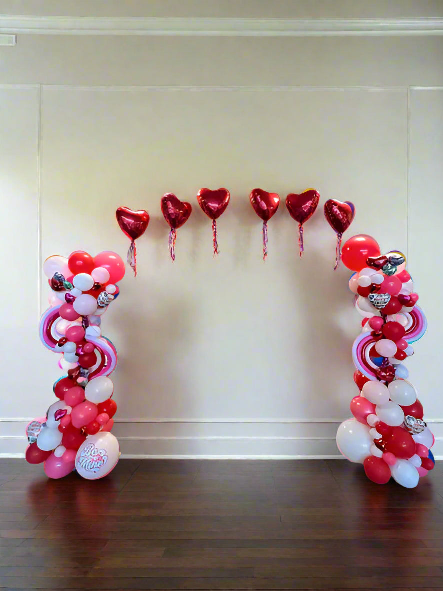 elaborate valentine balloon arch with hearts and tassels