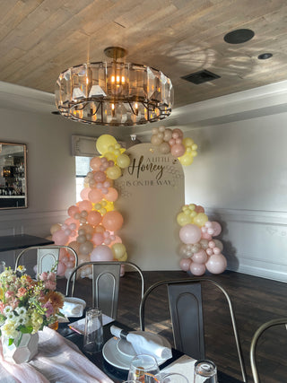 A baby shower themed event backdrop with balloons.