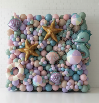 Mermaid-themed balloon arch with sea creatures and a figurine on a carpeted floor.