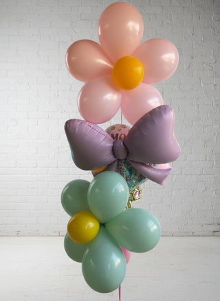 Balloon sculptures shaped like flowers and a bow on a white background.