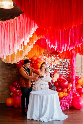 Bright pink and orange fringe wedding event decor with the 99 Haus Balloons and Decor custom event service