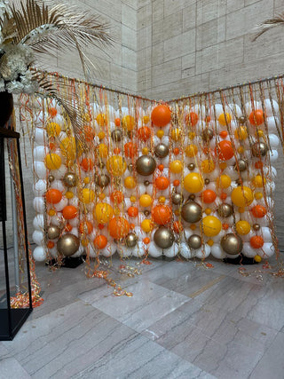 Orange and metallic balloon wall corporate balloon installation with the 99 Haus Balloons and Decor custom event service