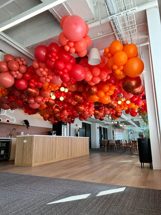 Red and orange ceiling corporate balloon installation with the 99 Haus Balloons and Decor custom event service