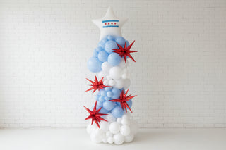 Balloon sculpture in the shape of a star with blue, white, and red colors in an indoor setting.