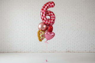 A helium bouquet featuring a large number 6 shaped balloon with a pizza pattern, accompanied by other shaped balloons in red and gold colors, tied together with a string.
