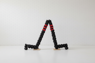 Black and red balloon sculpture of two hockey sticks
