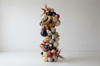 Decorative balloon arch with cowboy hats and stars in a room setting.