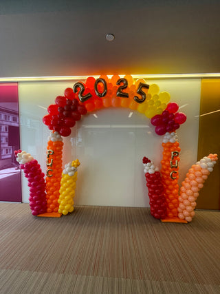 Orange red and yellow balloon arch with balloon numbers 2025 and balloon letters PWC for Price Water Cooper