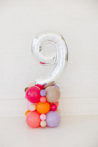 Decorative balloon shaped like the number '9' with colorful spherical balloons on a white background