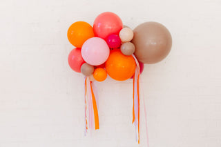 Colorful balloon arrangement with ribbons on a light background