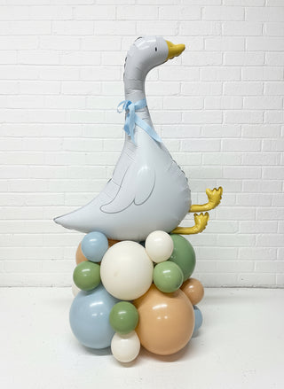 Decorative balloon sculpture shaped like a goose on a wooden surface.