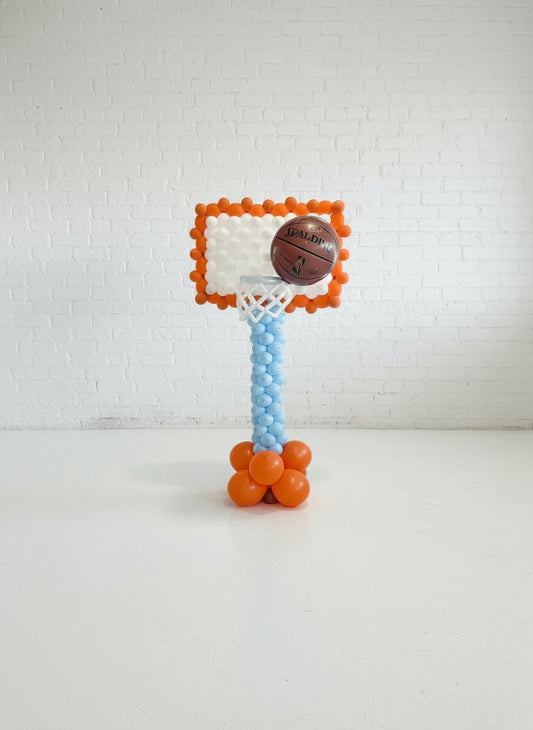 Small basketball hoop with a basketball on a white background
