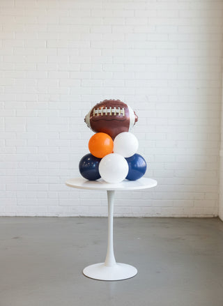 Football and balloons on a wooden table with a blurred background
