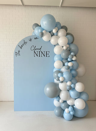 A bridal event backdrop with light blue and white balloons