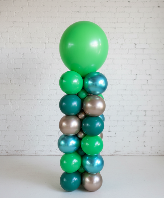 A column-like balloon arrangement featuring a series of round balloons in green, blue, and bronze colors, standing upright against a wall.