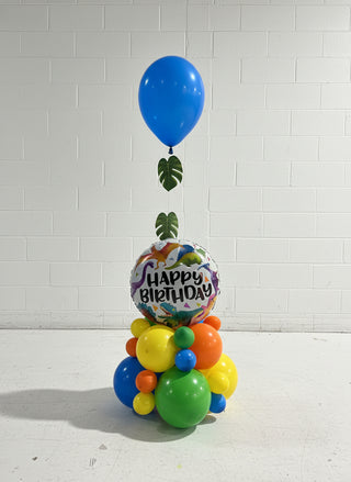 Colorful balloons with a 'Happy Birthday' balloon in a room with orange walls and blue floor.