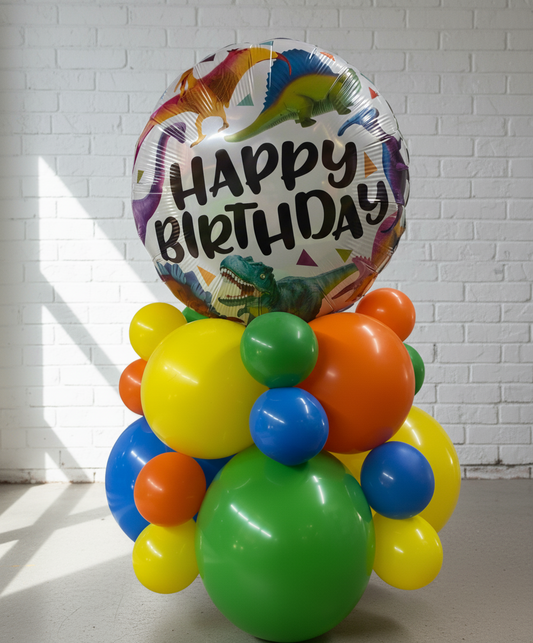 Colorful balloon arrangement with a 'Happy Birthday' balloon featuring dinosaur graphics on a white background.