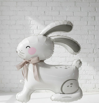 A white, air-filled balloon in the shape of an Easter bunny with a decorative bow.