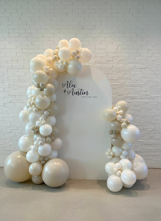 An all white and peral engagement backdrop with balloons