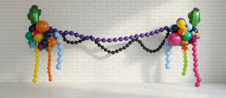 A colorful balloon swag decoration with a variety of balloons in different shapes and colors displayed across a room.