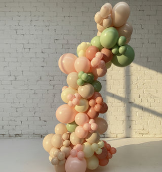 A freestanding balloon garland featuring a variety of pastel colors, arranged in a spiral pattern, inflation-based decoration.
