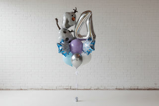 Balloon arrangement with a snowman character and number 4 against a brick wall.