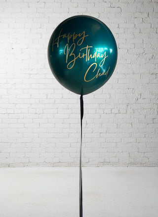 a jumbo green balloon reading Happy Birthday