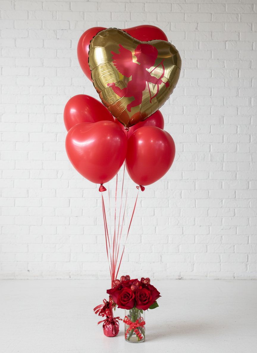 A helium balloon bouquet featuring a large gold heart-shaped balloon and smaller red heart-shaped balloons tied to a string, with a small red bow at the base.