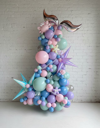 a mermaid themed freestanding balloon garland with blue and purple elements