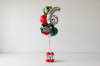 Large inflatable number '6' with balloons and text in a white studio