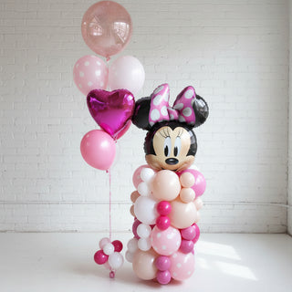 A helium balloon bouquet featuring a Minnie Mouse character design, with a column of balloons in a room.