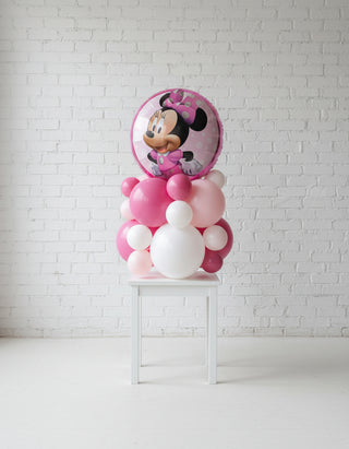A mouse-shaped tabletop decoration featuring a pink and white color scheme with a prominent character balloon on top.