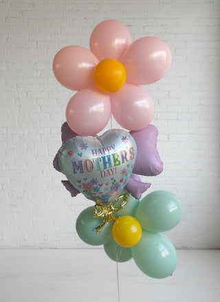 A helium bouquet featuring a 'Happy Mother's Day' balloon, along with other flower-shaped balloons in pink, blue, and yellow shades.