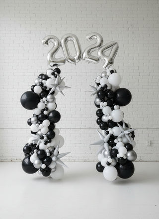 A freestanding balloon garland featuring black and white balloons with the numbers '2027' in helium.