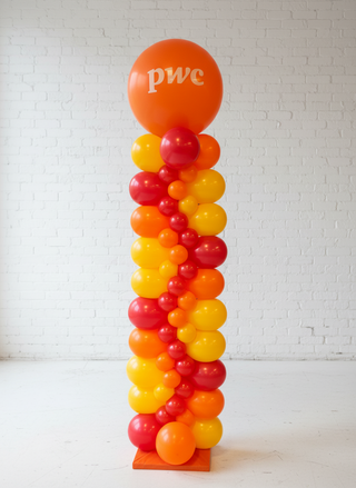 A zig zag column made of red and orange balloons with a PWC logo on the top balloon, set against a plain background.