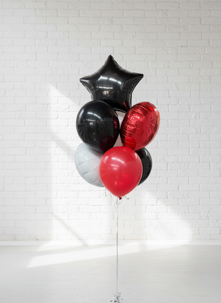 A bunch of balloons tied together with a black star-shaped balloon, a red balloon, and a white balloon visible in the image.