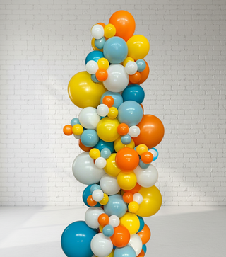 A freestanding garland of multicolored balloons in shades of blue, orange, yellow, and white, arranged in a wavy pattern to resemble a beach ball.