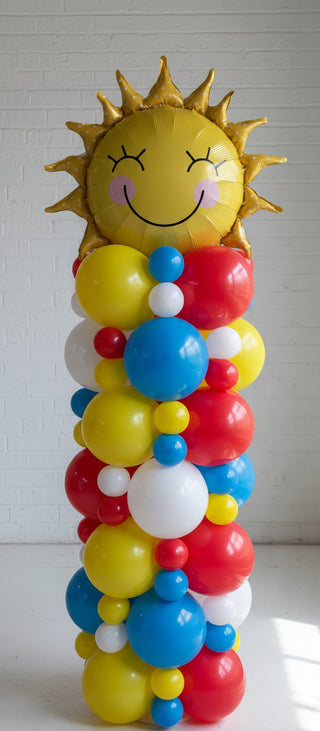 A colorful balloon column featuring a sun design on top with red, yellow, and blue balloons.