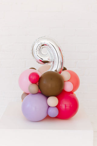Colorful balloon sculpture with a silver number 9 on a white background