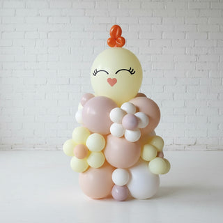 A decorative balloon column designed to look like an Easter chick with pastel colors and a smiling face.
