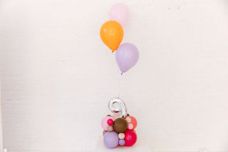 Colorful balloons and a decorative number on a white background