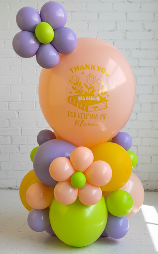 A balloon arrangement featuring a large pink balloon with the text 'THANKS for making my BIRTHDAY special', surrounded by smaller balloons in shades of purple, green, and peach, designed to look like flowers.