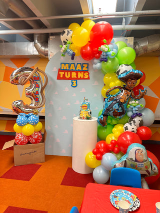 A toy story themed backdrop at a child's third birthday party. 