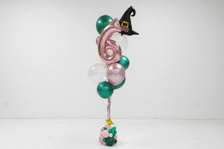 Colorful balloon arrangement with number 6 in a room with wooden floors and a decorative ceiling.