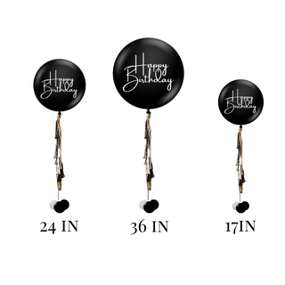 Three jumbo balloons with 'Happy Birthday' text in black color, each with different sizes, displayed with ribbons and weights.