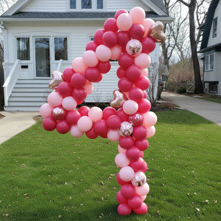 A set of large, round, pink and red balloons arranged in a number '4' formation for a yard display.